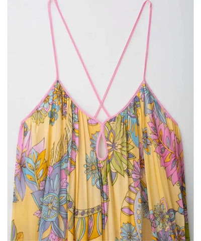 Detalhe das alças finas cruzadas do vestido longo floral amarelo