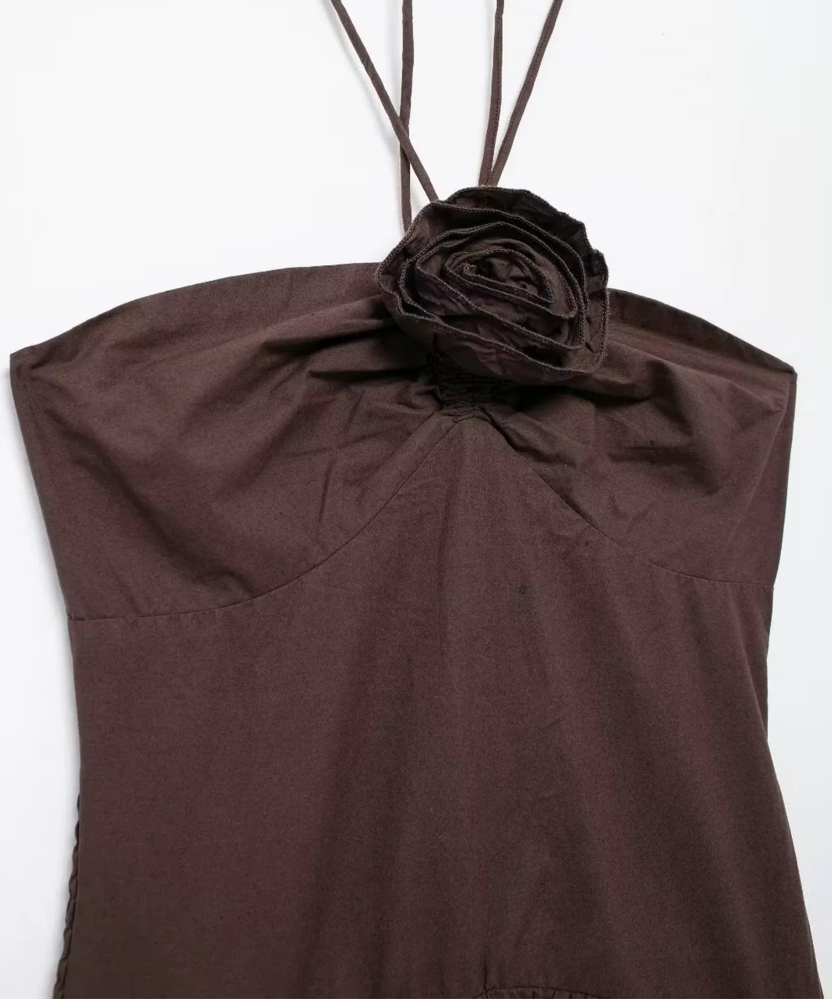 Detalhe do franzido no busto e aplique floral do vestido longo marrom